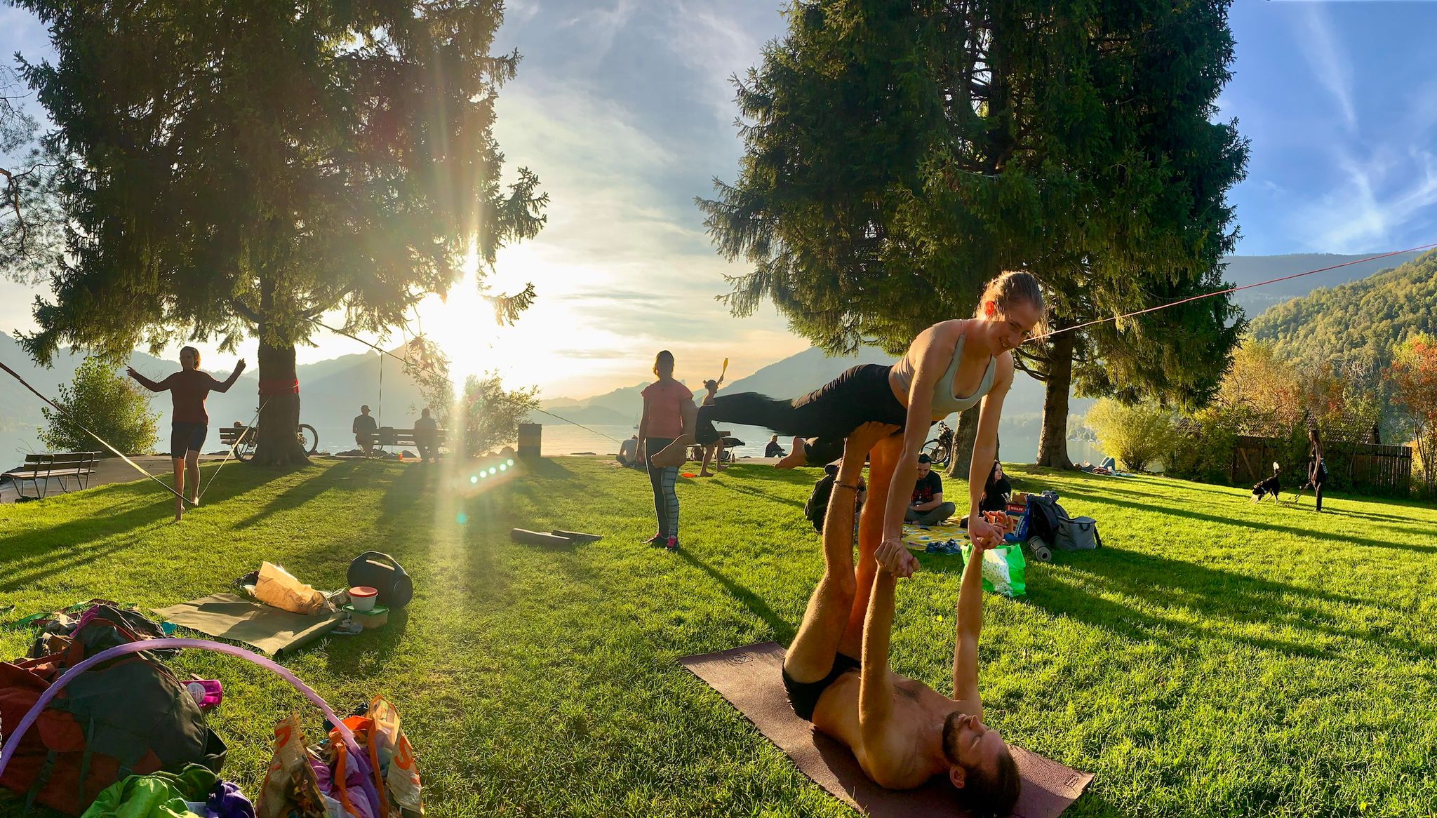 Two members of MOVE Interlaken enjoying AcroYoga in the sunset on the lake at the Kifferinseli